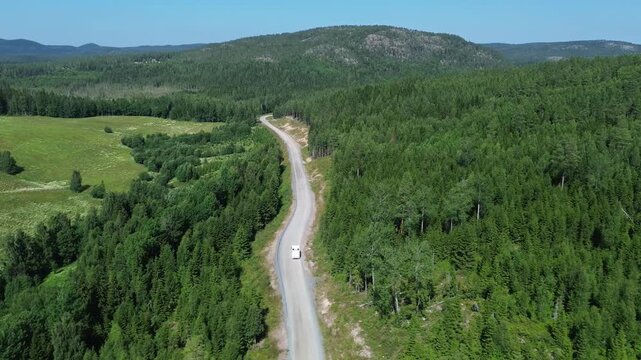 campervan driving through sweden on a small road in the forest