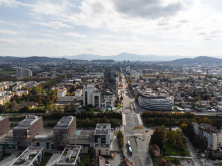 Obraz premium The aerial view shows Ljubljana, the capital city of Slovenia, with buildings and hills on a clear day.