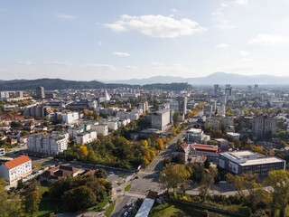 Obraz premium Urban landscape of Ljubljana, Slovenia with buildings and hills under a sunny sky. 
