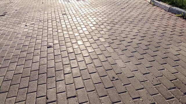 4K video of gray stone pavement on a public square shimmering in sunlight. Natural stone texture with sparkling reflections, ideal for backgrounds and b-roll footage.
