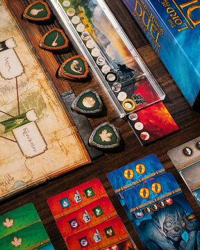 Portrait macro product photography of Lord of the Rings Duel Middle Earth showing Free Peoples faction tokens with horn sphere and tree leaf symbols designed by Antoine Bauza and Bruno Cathala