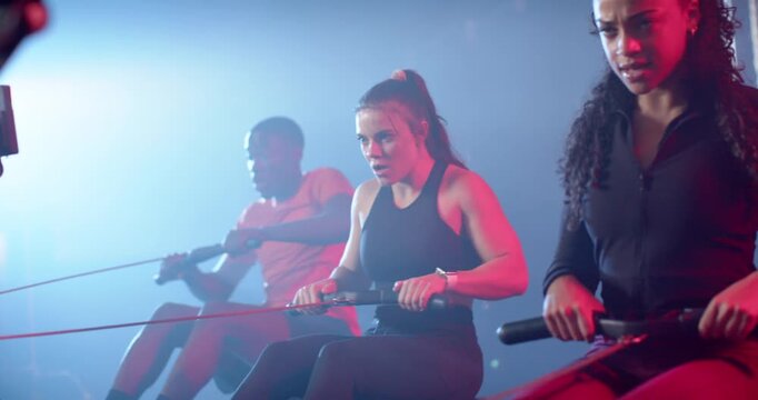 Workout partners gripping handles, pulling in sync while training in studio, copy space