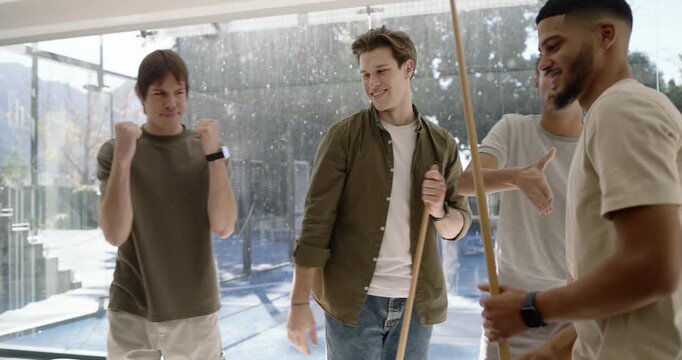 Diverse male friends pointing rack, African American man lining shot on felt table aiming to sink