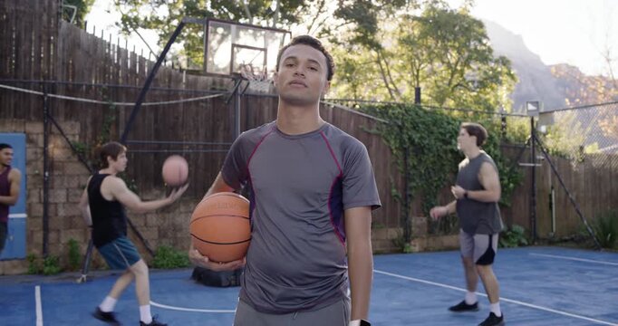 African American male dribbling basketball during pickup court, securing underarm posing for camera