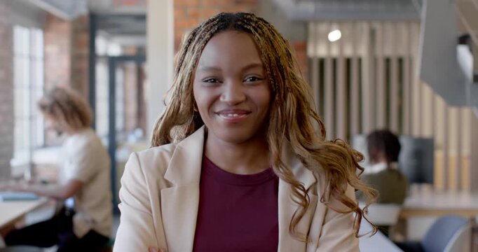 Diverse team African American woman arms crossed shifting to smile as cam zoom confident at office