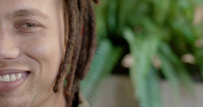 African American man smiling, widening, squinting after offscreen cue in studio, fern, copy space