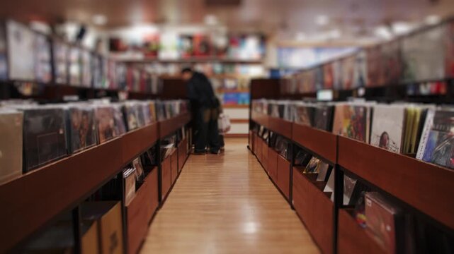 Person browsing vinyl records in store aisle