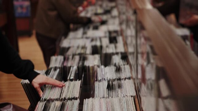 Person browsing through a large vinyl record collection