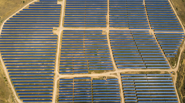 Aerial view of large solar farm generating sustainable green energy in a vast desert landscape