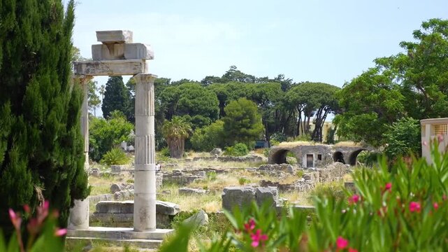 Ancient agora ruins in Kos, Greece, surrounded by lush greenery in slow motion 60fps