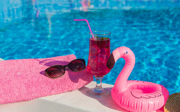 pink cocktail with flamingos on the background of the pool. Selective focus.