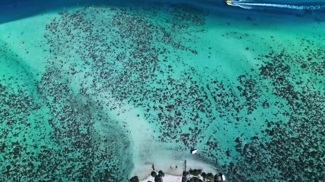 Drone flying away from tropical island in bora bora lagoon