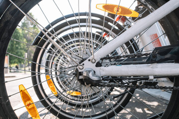 Fototapeta premium Wheels of contemporary rental bikes parked in row on sunny day in Madrid, Spain