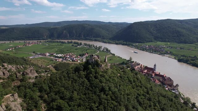 Aerial pull back view of hilltop castle ruins at D&uuml;rnstein at the banks of the Danube River in Wachau Region of Lower Austria