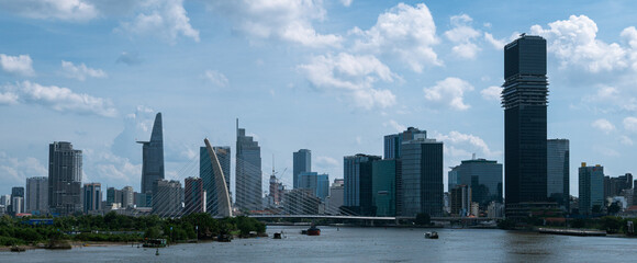 Fototapeta premium Daytime panoramic cityscape of Ho Chi Minh City skyline with Ba Son Bridge and Marina Central Tower, Saigon River, Vietnam