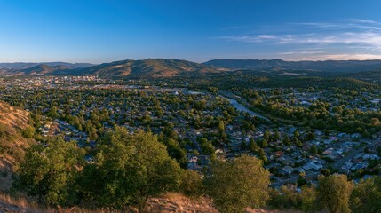 Fototapeta premium Golden hour panorama over Medford, Oregon West Side featuring mountains, river and distant urban skyline