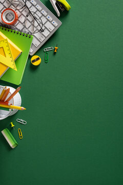 Back to school vertical green workspace with stationery, notebook, keyboard and glasses for study and planning