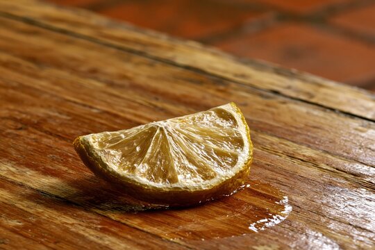 Juicy Lemon Wedge on Wooden Surface
