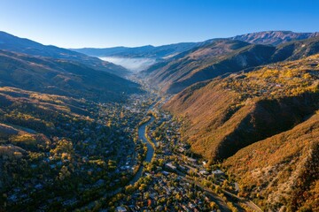 Fototapeta premium Drone view of fall colors shaping Glenwood Springs countryside and mountains