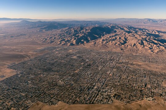 Desert valley cityscape from above: Palmdale urban grid with rugged mountain backdrop