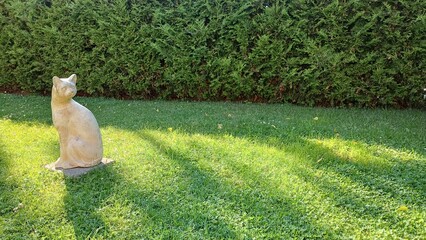 White cat statue on lawn with copyspace. Backyard garden decoration and landscape design template. © Green'landia