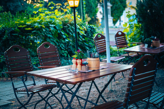 Eingedeckter Holztisch in einem traditionellen fr&auml;nkischen Biergarten im sommerlichen Abendlicht