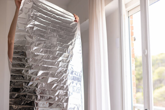 Man holding unrolled sun protection foil film for windows.