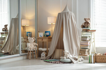 Beautiful wigwam, different toys and books in child's room. Interior design © New Africa