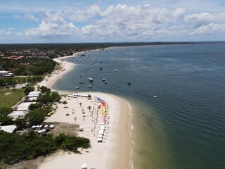Aerial view of Praia da Gamboa with white sand, anchored boats, beach umbrellas, and tropical coastline in Bahia, Brazil © Luan