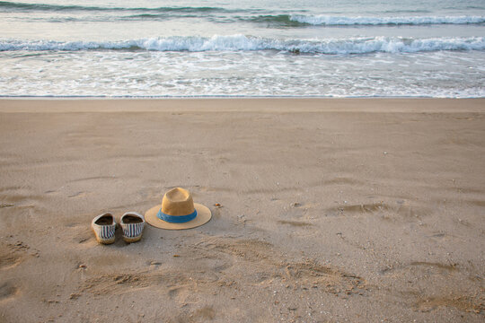 Panama hat and espadrilles on quiet sandy beach