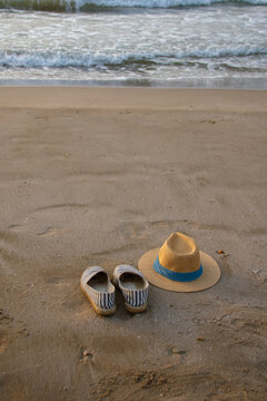 Vertical panama hat and espadrilles beside calm sea