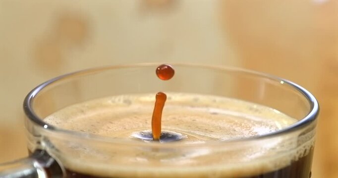 Falling drop into coffee cup, super slow motion