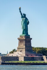 Statue of Liberty rises against a vibrant blue sky during a bright and sunny afternoon in New York harbor. © MohamedIbrahim