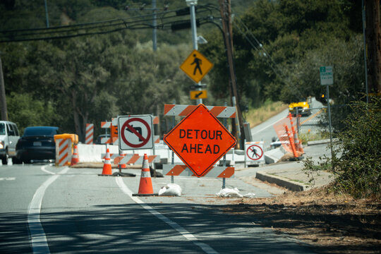 Road construction detour ahead with traffic cones and warning signs