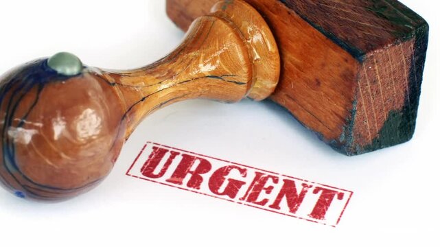 Rubber Stamp Marking Urgent Approval on Official Document Close Up