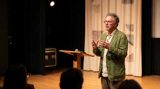 Film director speaking passionately on stage at an event  