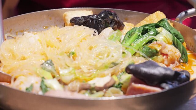 Sizzling Chinese hot pot with vermicelli noodles and vegetables