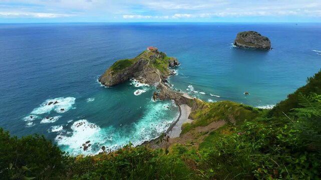serene aerial view of rocky coastline with green vegetation and ocean waves. travel and tourism destination. nature and landscapes scene. blue and green colors.