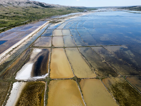 Aerial drone view of Pag Island salt pans or Solana Pag, Croatia. Colorful Salt Evaporation Ponds and Adriatic Landscape