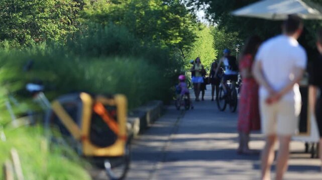 Unrecognizable people walking on the streets of Warsaw. People walking in the park. Sunny, hot, summer weather.