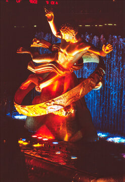 Illuminated golden Prometheus statue and fountain at Rockefeller Plaza at night in NYC