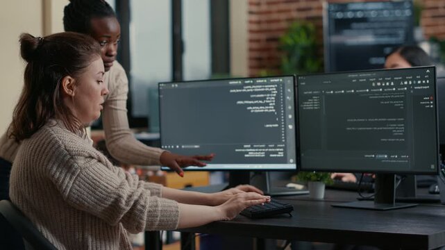 Junior software developer presents source code on a laptop for colleague opinion, supporting collaborative debugging and professional feedback, inside a software quality review.