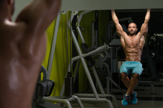 Young Man Performing Hanging Leg Raises Exercise
