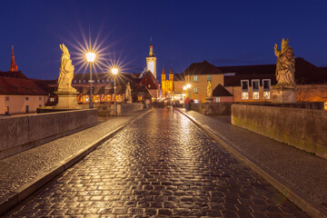Naklejka premium View of the Old Main Bridge with baroque statues leading toward the historic city center of Wurzburg, Bavaria, Germany.