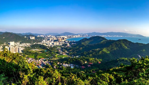 Panoramic view of a coastal city nestled in lush green hills under a blue sky
