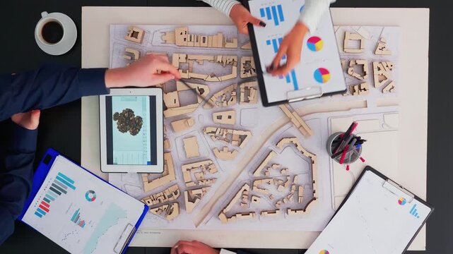 Engineers brainstorm an ambitious turbine design project in a corporate boardroom, working with schematics, devices, planning documents and copy space.