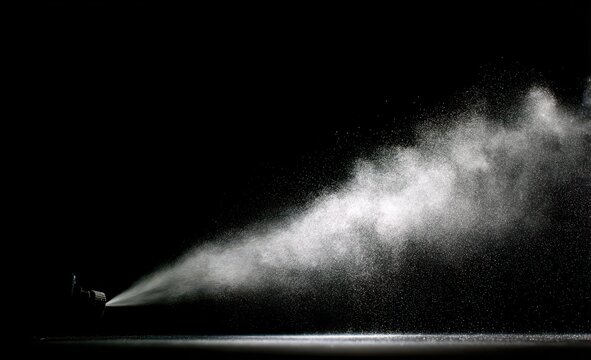 Professional spraying mist particles against dark background with droplets particle background pressure moisture freshness spraying contrast lighting cosmetic cleansing atmosphere isolated