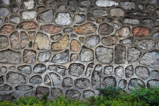 Irregular Natural Stone Wall Made with Mortar and Greenery at Bottom
