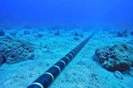 Underwater submarine fiber optic cable stretching across the ocean floor, illustrating global internet infrastructure, telecommunications, connectivity, technology and digital communication.