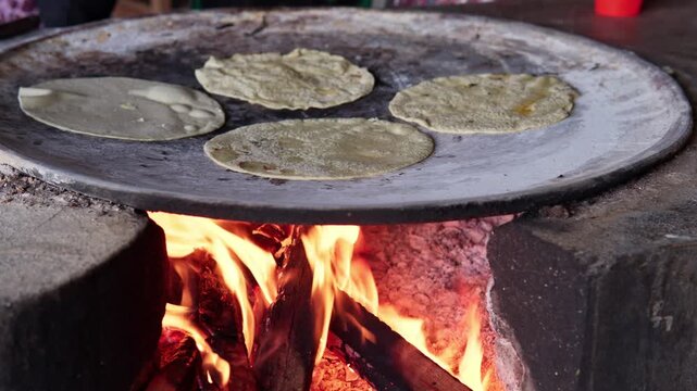 Mexican corn tortillas cooking on a traditional clay comal